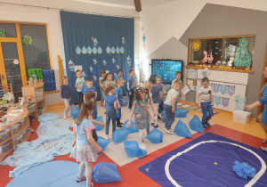 dzieci tańczą z niebieskimi workami